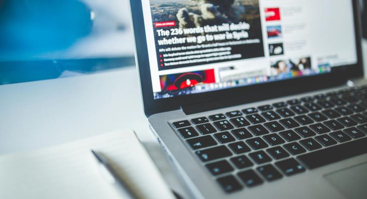 gray laptop computer near journals